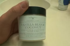 Jar of vanilla bean and coconut sugar scrub on a white surface